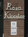 908000 Afbeelding van het siersmeedwerk 'Rosaklooster' en nieuwe huisnummerbordjes op de gevel naast de ingang van het ...